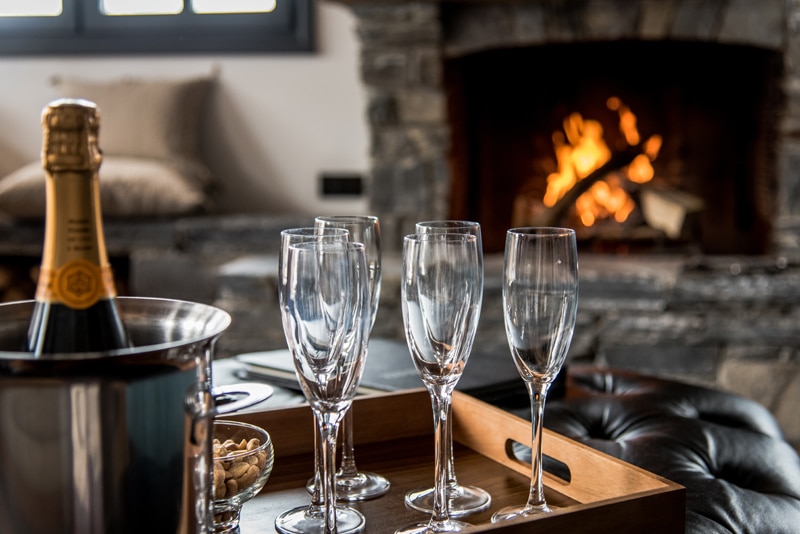 Salon avec feu et champagne au chalet de ski de luxe Tomkins à Méribel